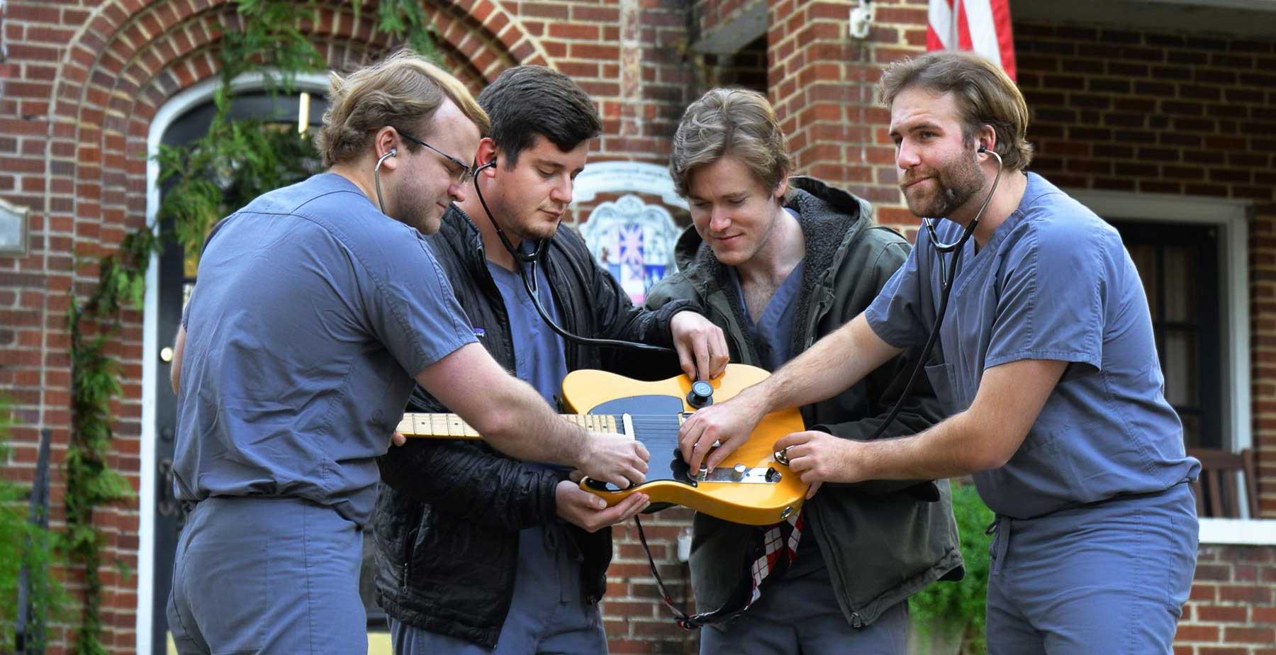 Members of the Grey Scrubs, one of five bands set to compete at the USA Health Doc Rock fundraiser on Jan. 30 at the Soul Kitchen in downtown Mobile. They are holding a guitar. 